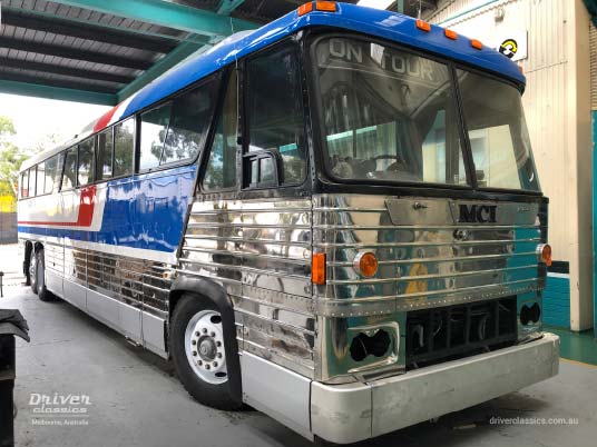 1976 MCI MC8 under restoration, Mt Waverley VIC, June 2019 MCI MC8 bus (1976 version), front and side, under restoration, in workshop, Pepsi red white and blue stripes, Mt Waverley VIC, Photo taken April 2019