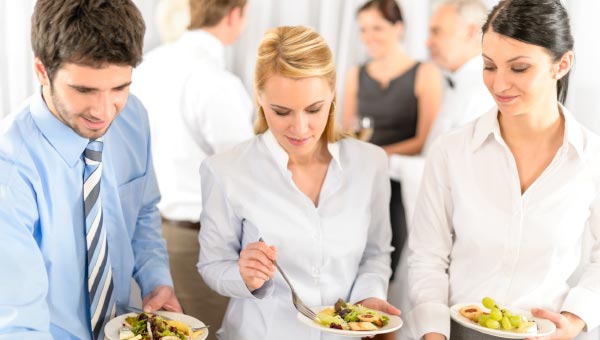 Office staff out at office Christmas party lunch, dishing themselves up lunch