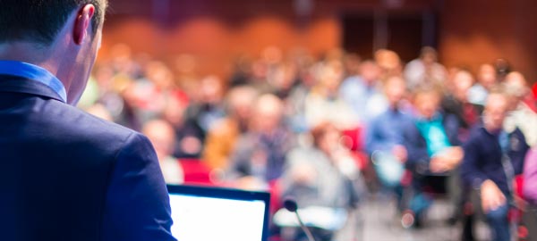 Presenter at conference speaking to crowd