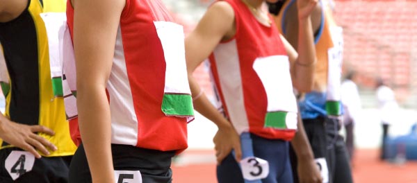 Track and field runners at school sports prepare to run